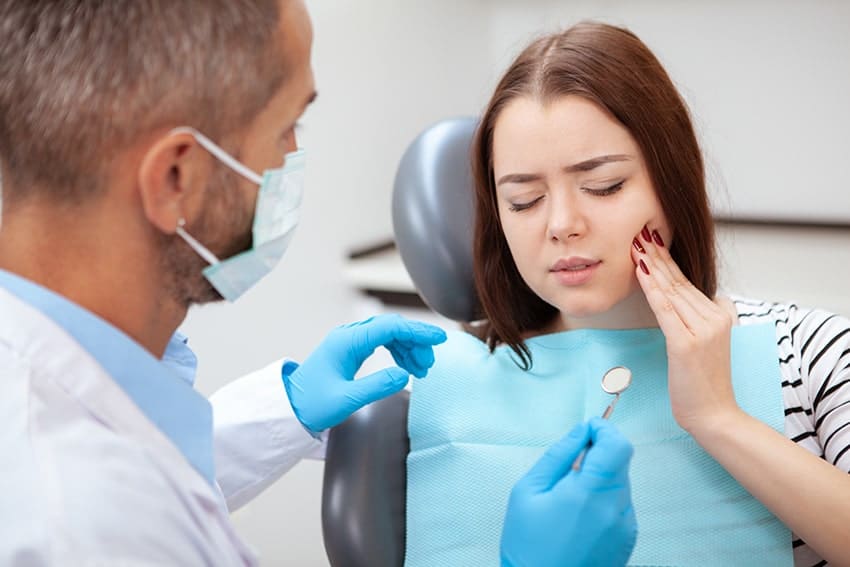 Young woman discussed her tooth pain with her dentist