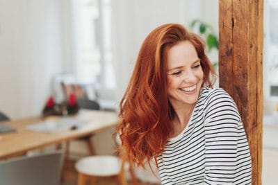 beautiful red haired woman laughing in her studio at home