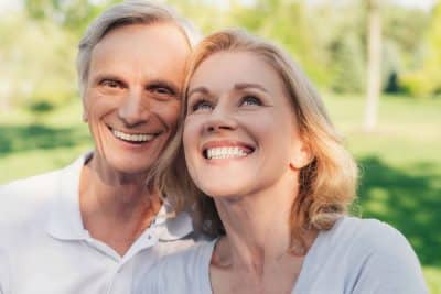 beautiful couple showing off their confident smiles with dental implants